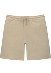 Shorts décontractés beige avec taille élastique et cordon de serrage, détails de couture à l'avant et un petit logo près de l'ourlet sur la jambe droite.