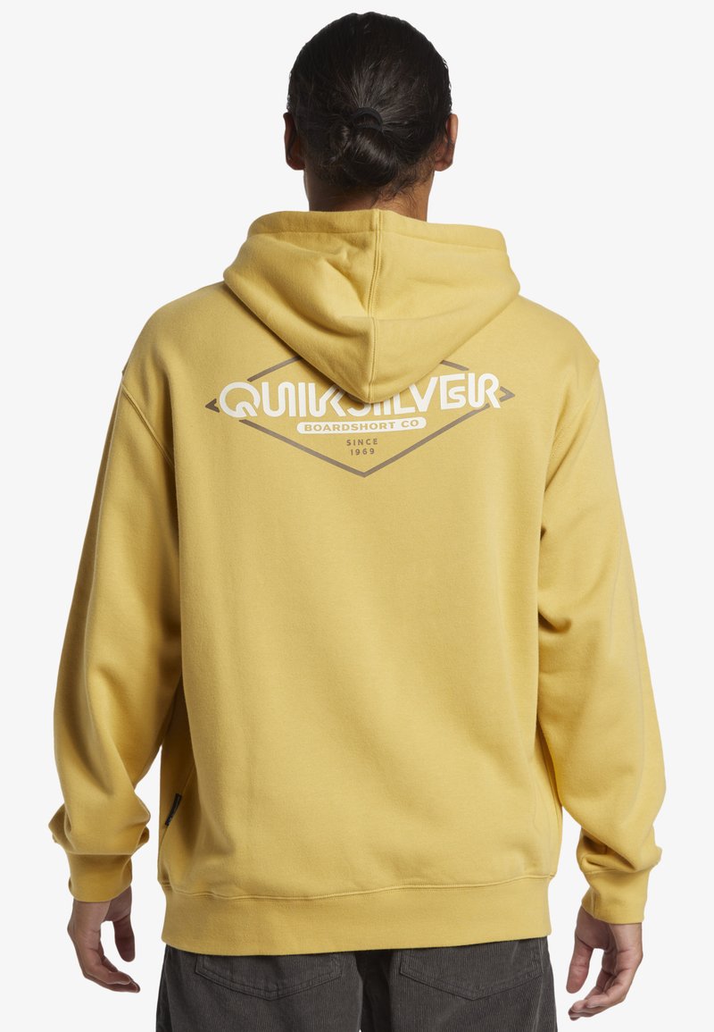 Yellow hoodie with a large white Quiksilver logo on the back. Made of soft fabric, featuring a kangaroo pocket and elastic cuffs.