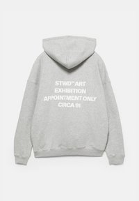 Grå hoodie i mjukt tyg, med en stor vit grafisk text på baksidan: "STWD™ KONSTUTSTÄLLNING ENDAST MED TID CIRC 91."