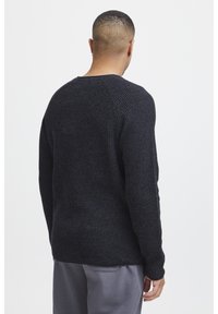 Pull en tricot gris foncé avec une finition texturée, doté d'un col rond et de manches longues, vu de dos.