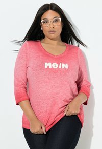 Rød ombre T-shirt med V-hals og trekvartærmer, med hvidt grafisk tekst "MOIN" og ankerdesign foran.