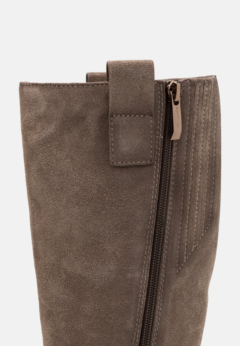 Bottine en cuir suédé marron avec une fermeture éclair sur le côté, dotée d'un panneau texturé et d'un détail en boucle en haut pour un enfilage facile.