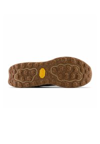 Brown textured rubber shoe sole with aggressive tread pattern and yellow Vibram logo in the center, isolated on white background.