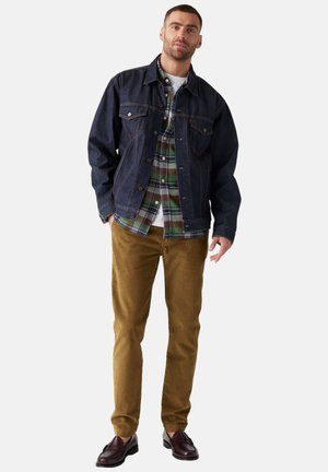 Denim jacket, plaid shirt with green and navy tones, brown corduroy pants, and burgundy shoes. Casual layered outfit with button details.