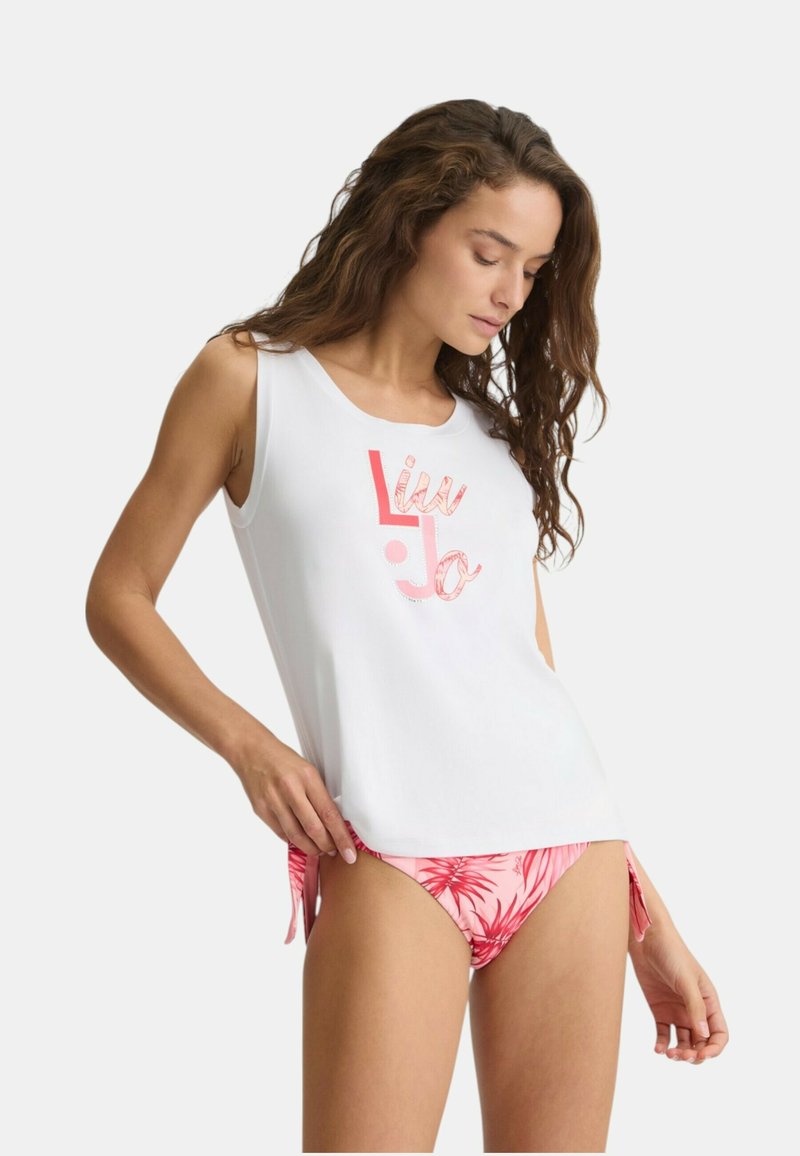Top bianco senza maniche con scollatura rotonda e grafica "Liu Jo" rosa, abbinato a slip da bikini rosa con motivo di foglie tropicali e lati con lacci.
