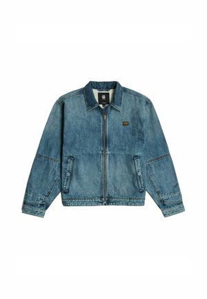 Denim jacket in light blue with a zip front, pointed collar, side pockets, and contrasting stitching. Features a small logo patch on the chest.