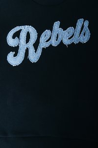 Black sweatshirt featuring blue denim embroidered text "Rebels," with frayed edges, set against a smooth fabric backdrop.
