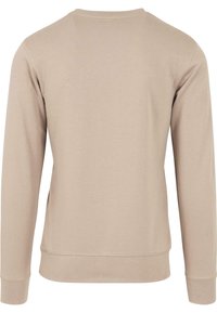 Sweatshirt bej cu mânecă lungă și decolteu rotund, realizat dintr-un material moale din amestec de bumbac. Are manșete și tiv ondulate, cu o textură netedă.