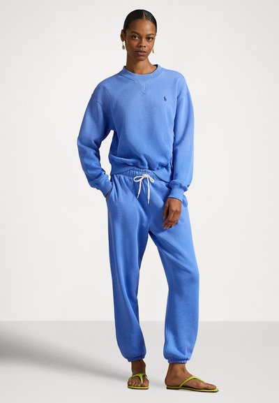 Sweatshirt azul em mistura de algodão com gola redonda e punhos canelados, combinada com calças de treino correspondentes, com cintura elástica e cordão ajustável.