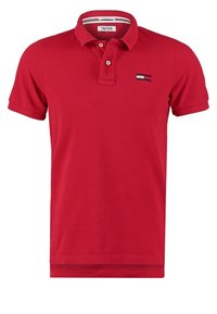 Polo rouge à manches courtes avec col et patte à deux boutons, doté d'un petit logo rectangulaire sur le côté gauche de la poitrine.
