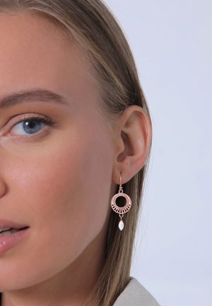 Rosaguldne, cirkulære øreringe med indviklet detaljer og en hængende klar ædelsten. Med en hoop-design og åben midte.