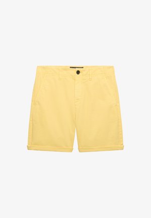 Shorts chino jaunes pour hommes avec bouton avant, passants de ceinture, poches latérales et ourlets roulés sur fond blanc.