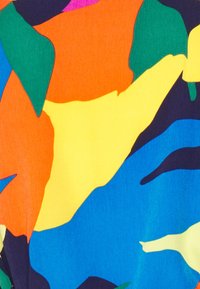 Färgg cloth med abstrakta blommönster i orange, gult, grönt, blått och lila mot en texturerad bakgrund.