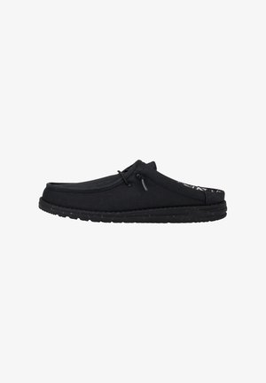 Schwarze Slipper aus weichem Material, mit runder Zehenpartie, niedrigem Profil und strukturiertem Gummisohle mit Akzentnähten.