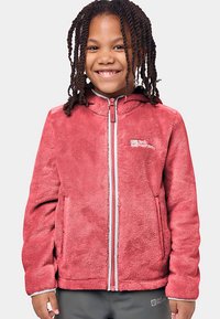 Piros polár dzseki kapucnival, elülső cipzárral és oldalzsebekkel. Puha tapintású, jellegzetes rétegzett kialakítású, logóval a bal felső mellrészen.