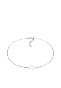 Silver chain bracelet featuring a quatrefoil charm at center. The chain is delicate with a lobster clasp and adjustable length.