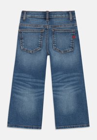 Blaue Denim-Jeans mit weitem Bein, ausgestattet mit zwei Gesäßtaschen, oranger Naht und leicht verwaschenem Textur.