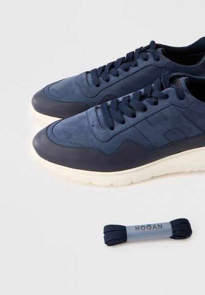 Baskets en cuir bleu avec une finition lisse, dotées de lacets texturés, de semelles en caoutchouc et d'un accent de logo. Comprend un lacet supplémentaire bleu.