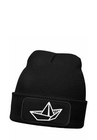 Black knitted beanie with a thick ribbed texture, featuring a white paper boat graphic on a black patch on the cuff.