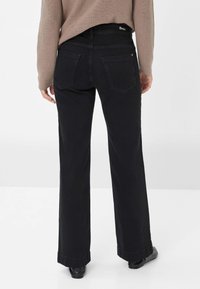 Zwarte wijde denim jeans met een hoge taille, achterzakken en een subtiele logo op de tailleband. Schone, rechte pasvorm.