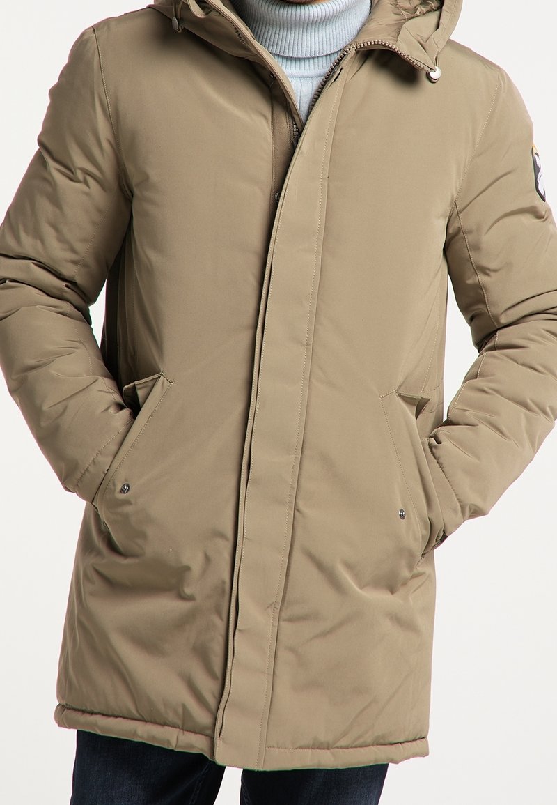 Doudoune beige avec capuche, dotée d'une fermeture éclair frontale, de poches latérales et d'un tissu lisse et texturé. Design simple avec des accents minimalistes.