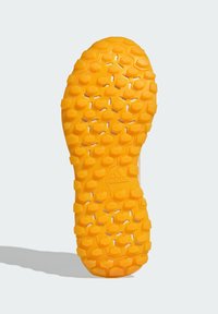 Semelle extérieure en caoutchouc jaune avec un motif hexagonal texturé, arborant le logo Adidas. Conçue pour offrir adhérence et durabilité en milieu extérieur.