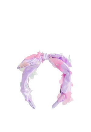 Diadema de tela lila con un lazo anudado y apliques de flores translúcidas rosas y blancas esparcidos por ella.