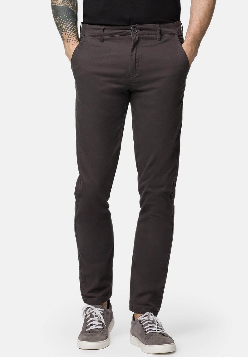 Szare bawełniane chinosy o slim fit, z zamkiem błyskawicznym, przednimi kieszeniami i subtelną fakturą, w połączeniu z szarymi trampkami.