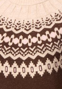 Beige und brauner gestrickter Pullover mit geometrischen und Zickzackmustern am Halsausschnitt in traditionellem Stil.