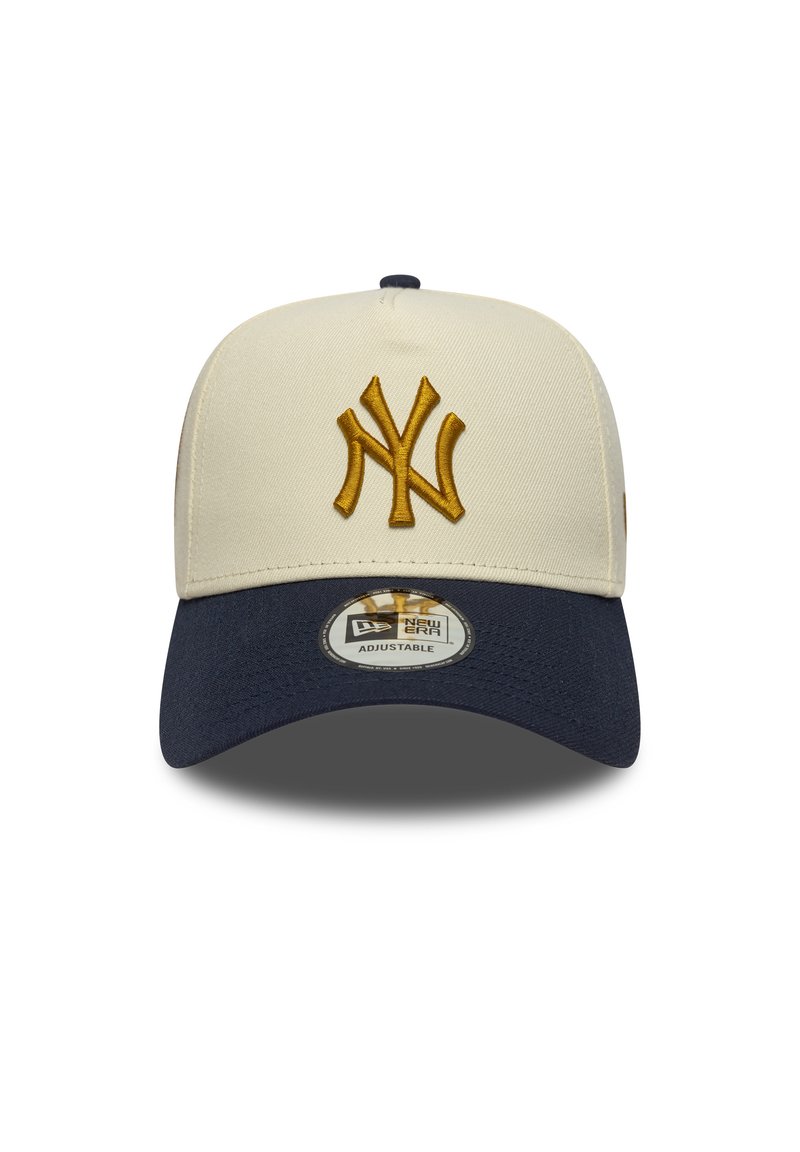 Verstellbare Baseballmütze in Creme mit einem dunkelblauen Schirm. Sie verfügt über ein auffälliges, goldfarben gesticktes "NY"-Logo und eine strukturierte Stoffoberfläche.