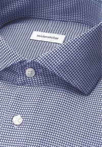 Camicia a maniche lunghe blu e bianca con motivo a righe, colletto a punta e bottoni bianchi, etichetta del marchio "seidensticker" all'interno del colletto.