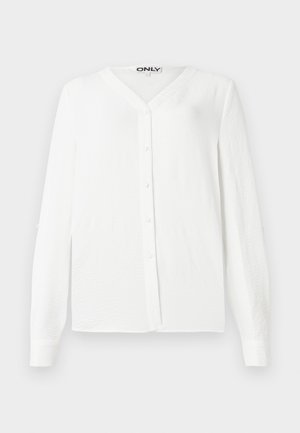 Fehér, hosszú ujjú ing V-nyakkivágással, gombos elülső résszel, texturált anyagból és egyenes szabással. Hat gombbal és szabványos mandzsettákkal rendelkezik.