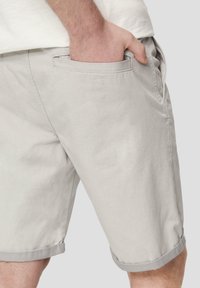 Lichtgrijze katoenen shorts met een omgerolde zoom en zijzak. Gerecyclede textuur, casual ontwerp, op maat gemaakte pasvorm.