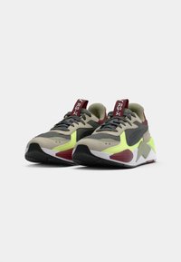 Athletic sneakers in gray, black, and lime green mesh and leather. Features a padded collar, textured accents, and patterned rubber sole.