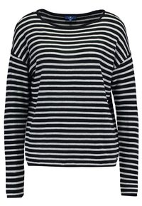 Haut à manches longues rayé noir et blanc, fabriqué en tissu doux, avec un large décolleté et une coupe ample, présentant des rayures horizontales.