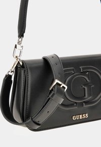 Borsa a spalla in pelle nera con logo impresso e hardware dorato, dotata di tracolla rimovibile e superficie liscia. Forma rettangolare compatta.