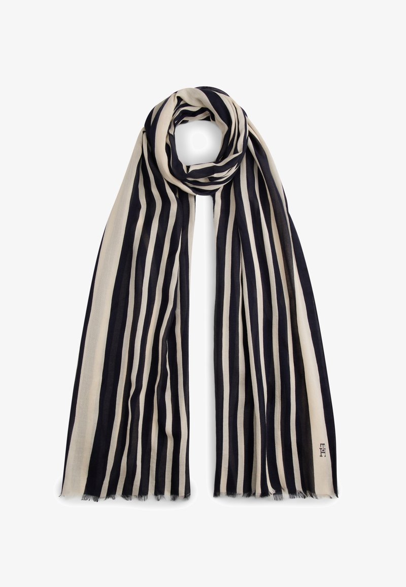 Ριγωτή εσάρπα από ελαφρύ ύφασμα με εναλλασσόμενες κάθετες ρίγες σε ναυτικό μπλε και κρεμ χρώμα· τελειώματα με ελαφριά ξεφτίσματα.