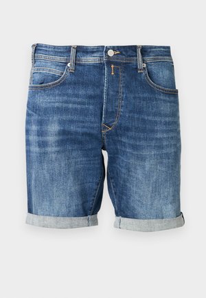 Džinsa šorti vidēja zilā tonī ar klasisku dizainu, kas ietver sarullētu apakšmalu, kontrastējošas šuves un priekšējās kabatas.