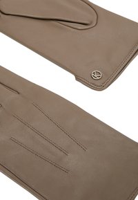 Braune Lederhandschuhe mit glatter Textur, die drei horizontale Nahtlinien auf der Rückseite und ein rundes Logo-Akzent in der Nähe des Handgelenks aufweisen.