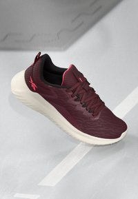 Burgundijske trkačke tenisice s teksturiranim gornjim dijelom, crnim detaljima i ružičastim akcentima. Imaju lagani potplat s rebrastim dizajnom za bolju prianjanje.