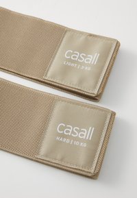 Dva bež traka otpora izrađena od teksturirane tkanine s bijelim etiketama na kojima piše "casall LIGHT | 3 KG" i "casall HARD | 10 KG."