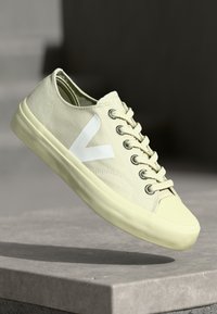 Sneaker in tela beige con logo V bianco, punta rotonda, occhielli in metallo e suola in gomma testurizzata, dotata di lacci e design a profilo basso.