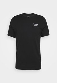 Camiseta negra de manga corta de Reebok con un pequeño logo blanco de Reebok en el lado izquierdo del pecho, presentada contra un fondo blanco liso.