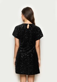 Černé šaty s flitry, krátké rukávy, volný střih, kulatý výstřih a detail ve tvaru klíčové dírky na zádech. Hladká textura, lesklý materiál.