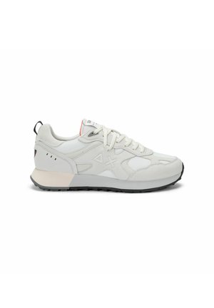 Scarpa da ginnastica bianca e grigio chiaro con lacci bianchi, pannelli strutturati e suola nera vista di profilo su sfondo bianco.