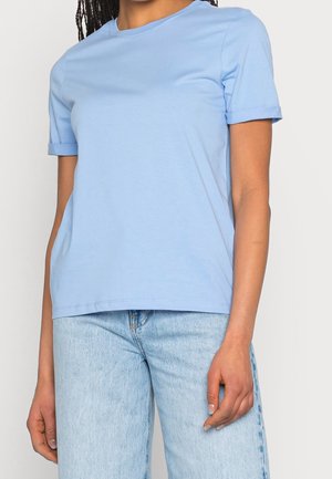 Lichtblauw T-shirt met korte mouwen gemaakt van zachte stof, met een ronde hals en opgerolde manchetten, gecombineerd met lichtblauwe spijkerbroek.