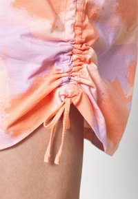Dragstring shorts i orange och lavendel tie-dye-mönster, med samlade sid sömmar och mjuk bomulls tyg.