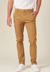 Beige Chinos aus Baumwollmischung mit geradem Schnitt, vorderen Taschen, Knopfverschluss und dezenten Stickdetails.