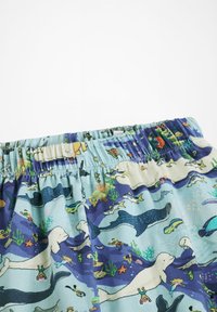 Svetlomodré látkové šortky s hravým vzorom morského života, ktoré obsahujú veľryby, žraloky a farebné ryby; elastický pás pre pohodlie.