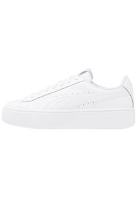 Sneakers bianchi con suola piatta, upper in pelle liscia, punta rotonda, lacci piatti e perforazioni laterali. Dettaglio del logo discreto sul tallone.